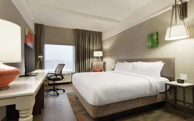 Contemporary king guest room with ergonomic workspace, comfortable seating and modern amenities at Hilton Garden Inn Calgary Downtown.