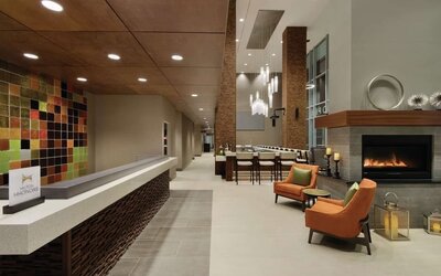 Stylish hotel lobby with fireplace, comfortable seating and modern reception area at Hilton Garden Inn Calgary Downtown.
