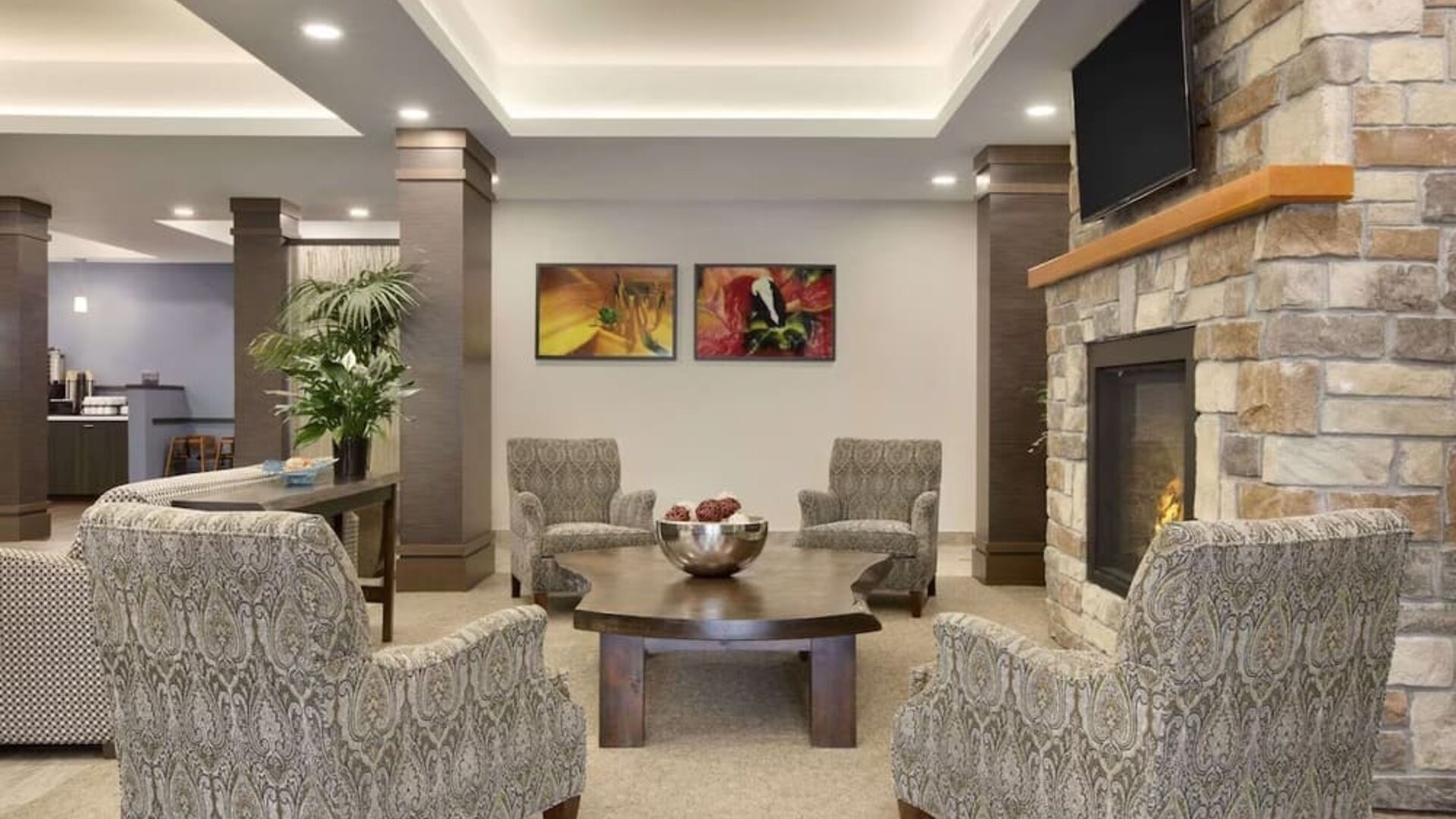 Inviting hotel lobby with fireplace, comfortable lounge seating and relaxing gathering space at Days Inn & Suites By Wyndham Lindsay.