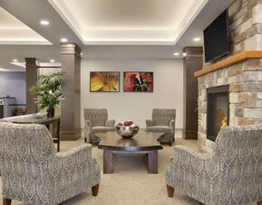 Inviting hotel lobby with fireplace, comfortable lounge seating and relaxing gathering space at Days Inn & Suites By Wyndham Lindsay.