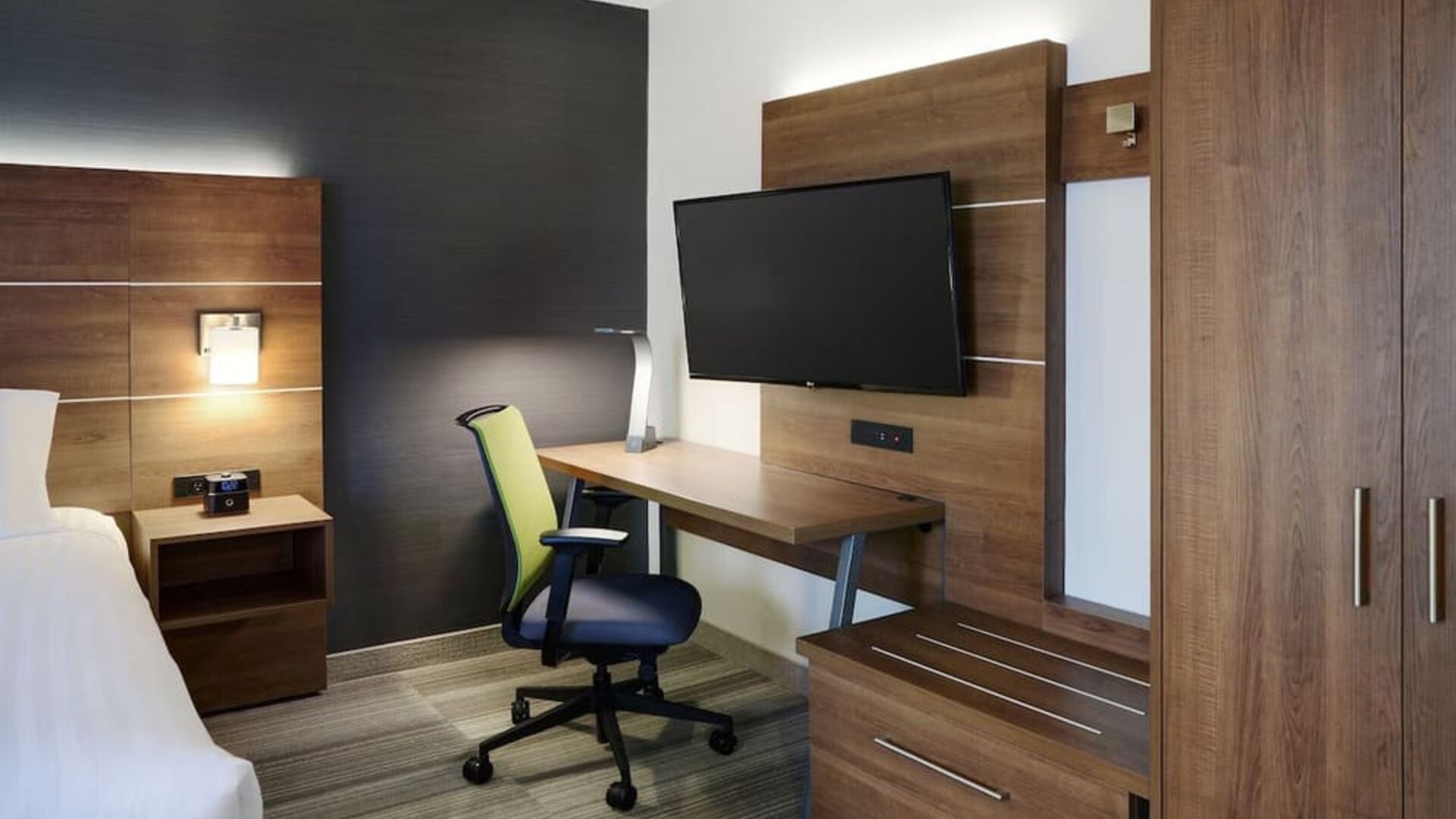 In-room workspace with ergonomic chair, flat-screen TV and ample storage at Holiday Inn Express Toronto Downtown.