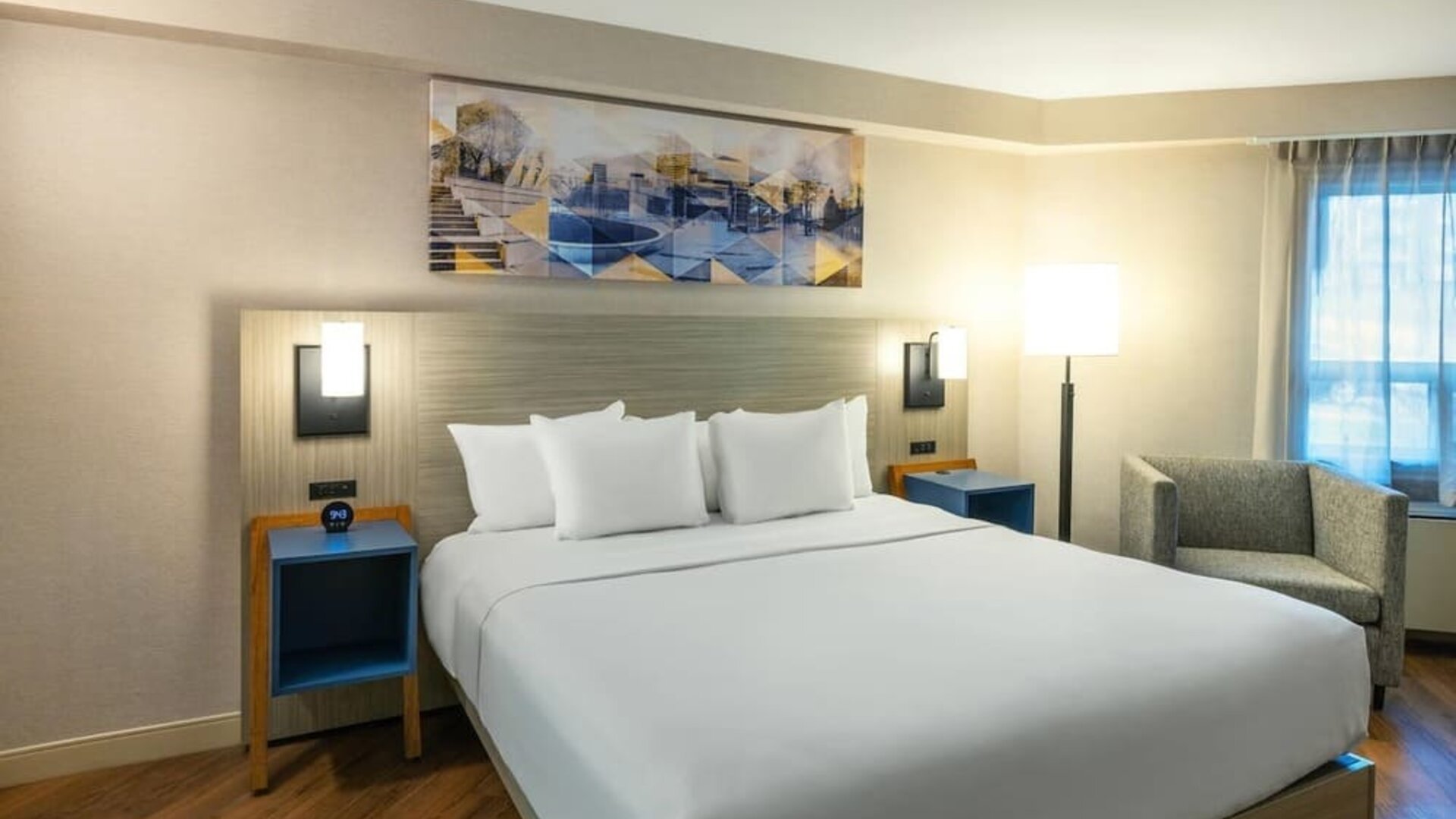 Inviting king bed with premium linens, bedside lighting, and cozy armchair for a relaxing stay at Comfort Inn Amherst.