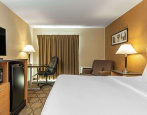 Spacious king guest room featuring premium bedding, microwave, mini fridge, work desk, and comfortable seating at Comfort Inn Thetford Mines.
