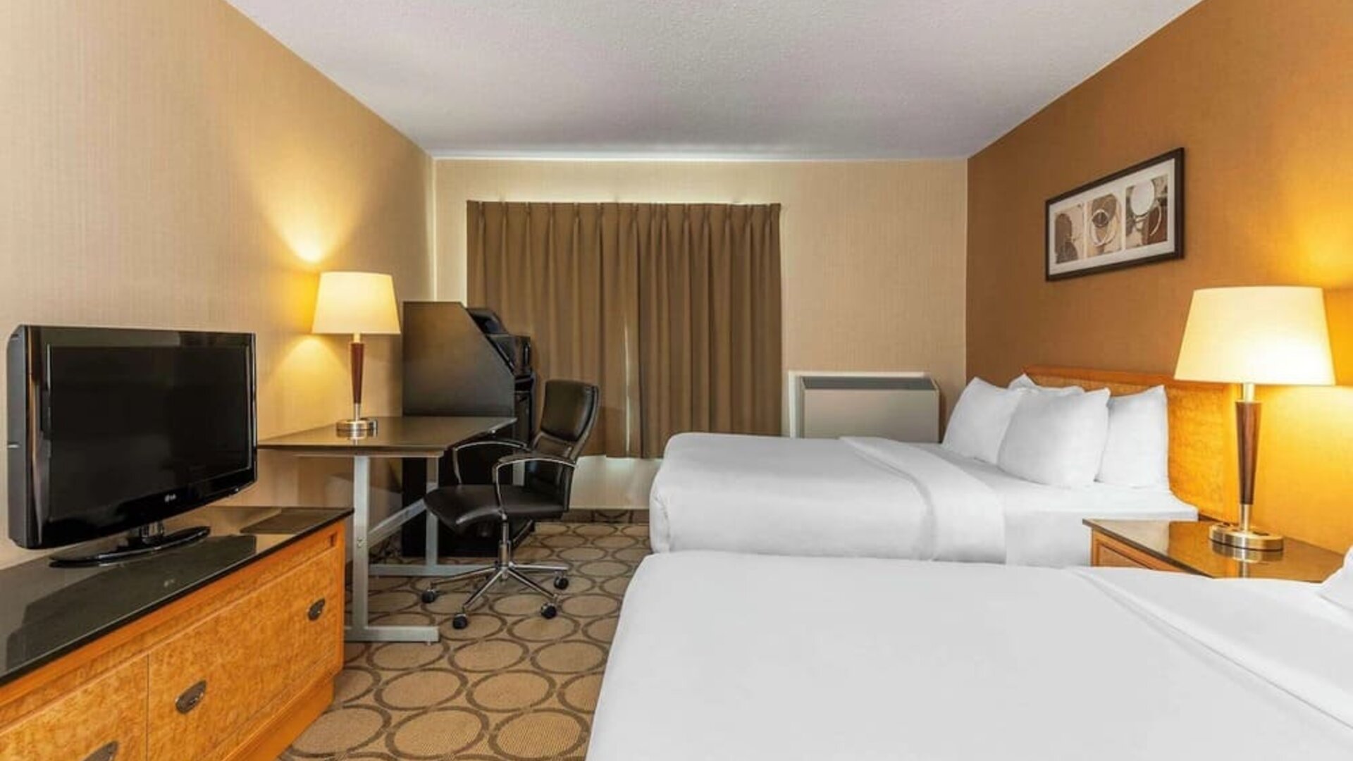 Guest room with two comfortable queen beds, ergonomic workspace, flat-screen TV, and modern amenities at Comfort Inn Thetford Mines.