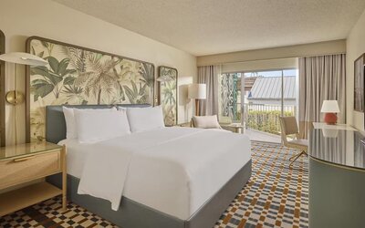 Bright king guest room featuring plush bedding, private balcony, ergonomic workspace, and contemporary coastal-inspired décor at Hyatt Centric Delfina Santa Monica.