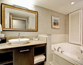 Contemporary bathroom featuring a whirlpool soaking tub, granite vanity, and modern finishes at Fairfield Inn & Suites Guelph.