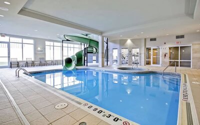 Spacious indoor pool featuring a waterslide, hot tub, and relaxing lounge area at Fairfield Inn & Suites Guelph.