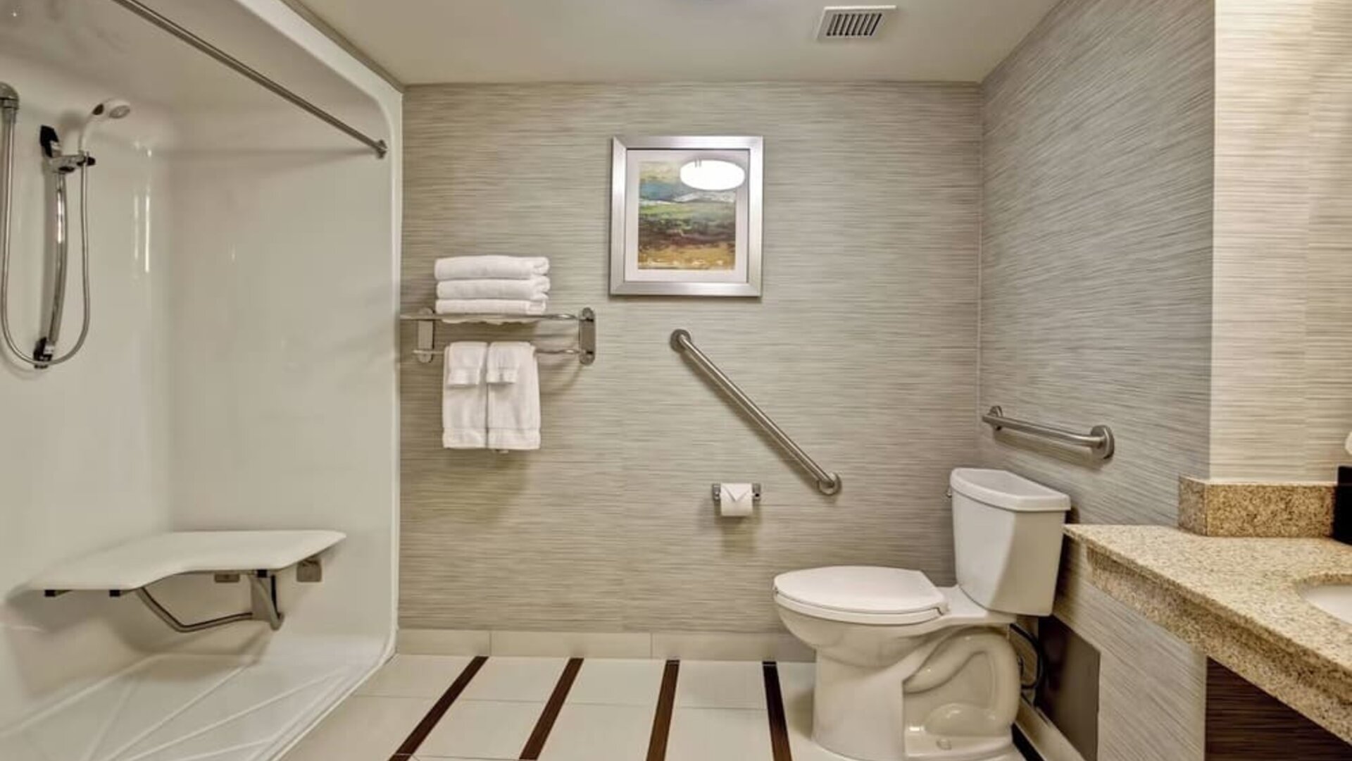 Accessible bathroom featuring a roll-in shower, grab bars, and modern vanity at Fairfield Inn & Suites Guelph.