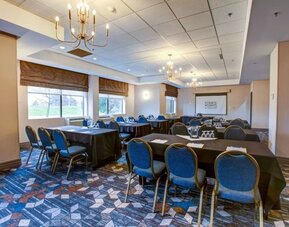 Flexible meeting room with banquet-style seating, presentation screen, and natural light at Four Points by Sheraton St. Catharines Niagara Suites.