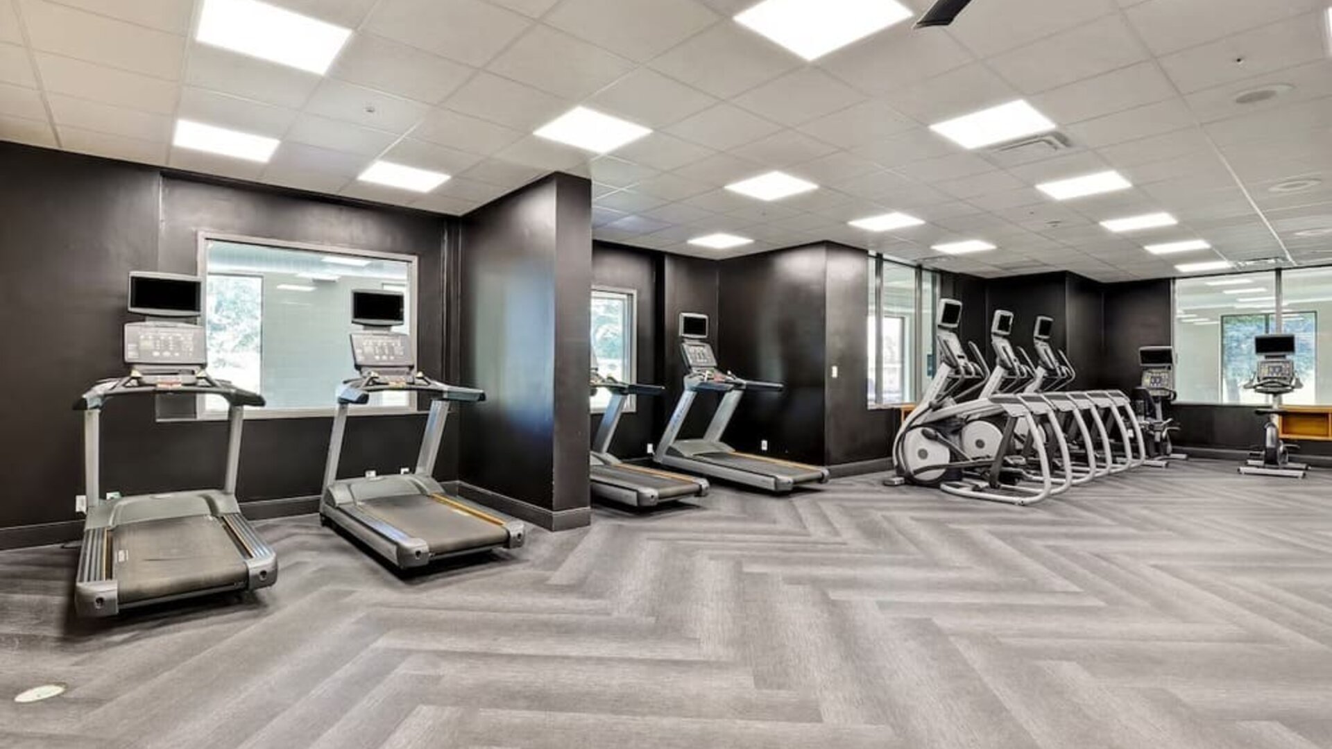 Spacious fitness centre featuring cardio machines and strength training equipment at Four Points by Sheraton St. Catharines Niagara Suites.