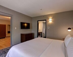 Spacious suite featuring a king bed, separate living area, and modern furnishings at Four Points by Sheraton St. Catharines Niagara Suites.