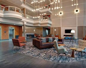 Bright atrium lobby with contemporary seating areas and elegant lighting at Four Points by Sheraton St. Catharines Niagara Suites.