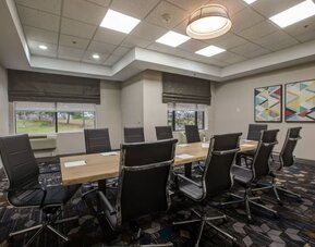 Executive boardroom with modern conference table and comfortable seating at Four Points by Sheraton St. Catharines Niagara Suites.