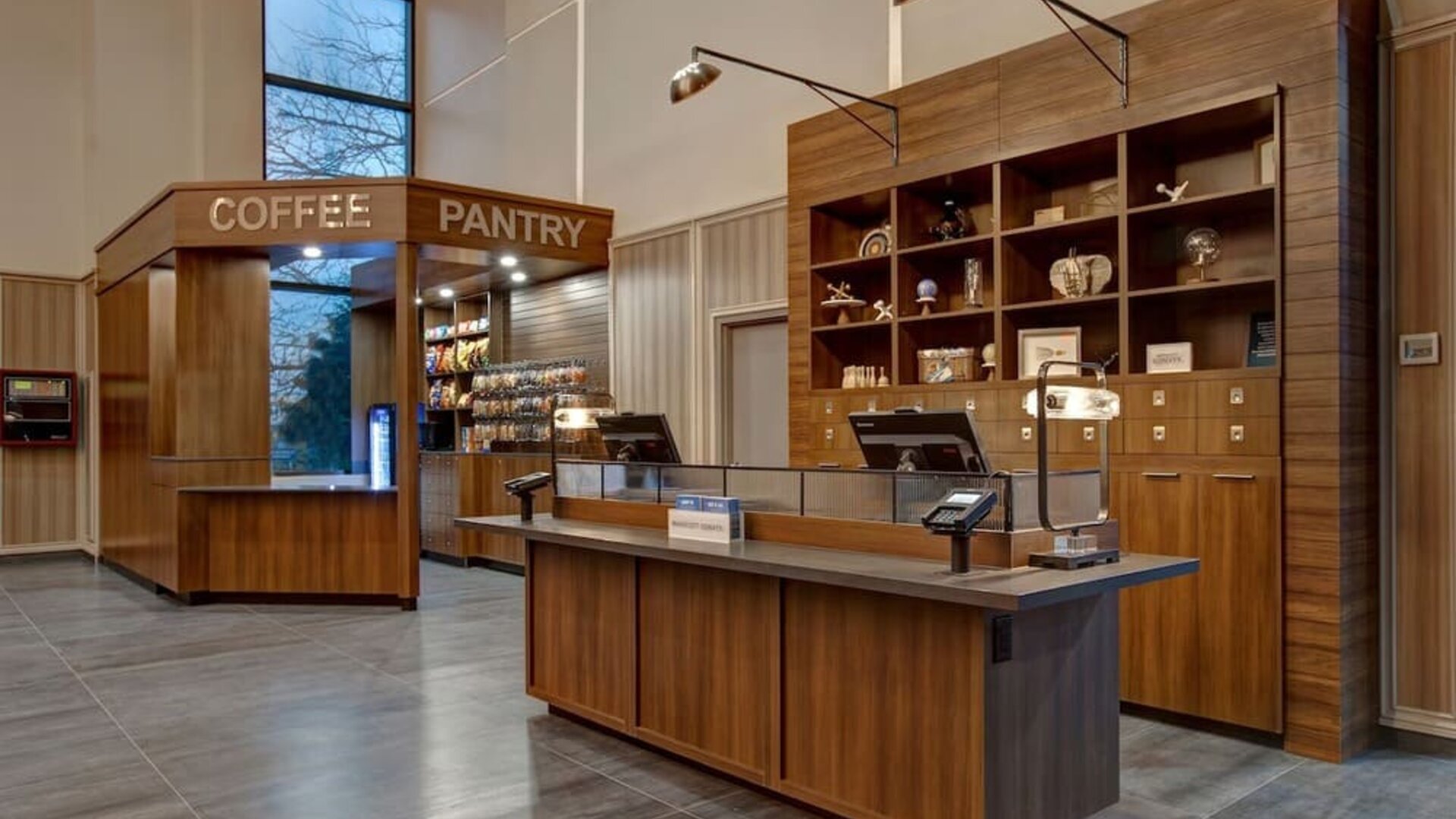 Reception desk with adjacent coffee pantry and convenience market at Four Points by Sheraton St. Catharines Niagara Suites.