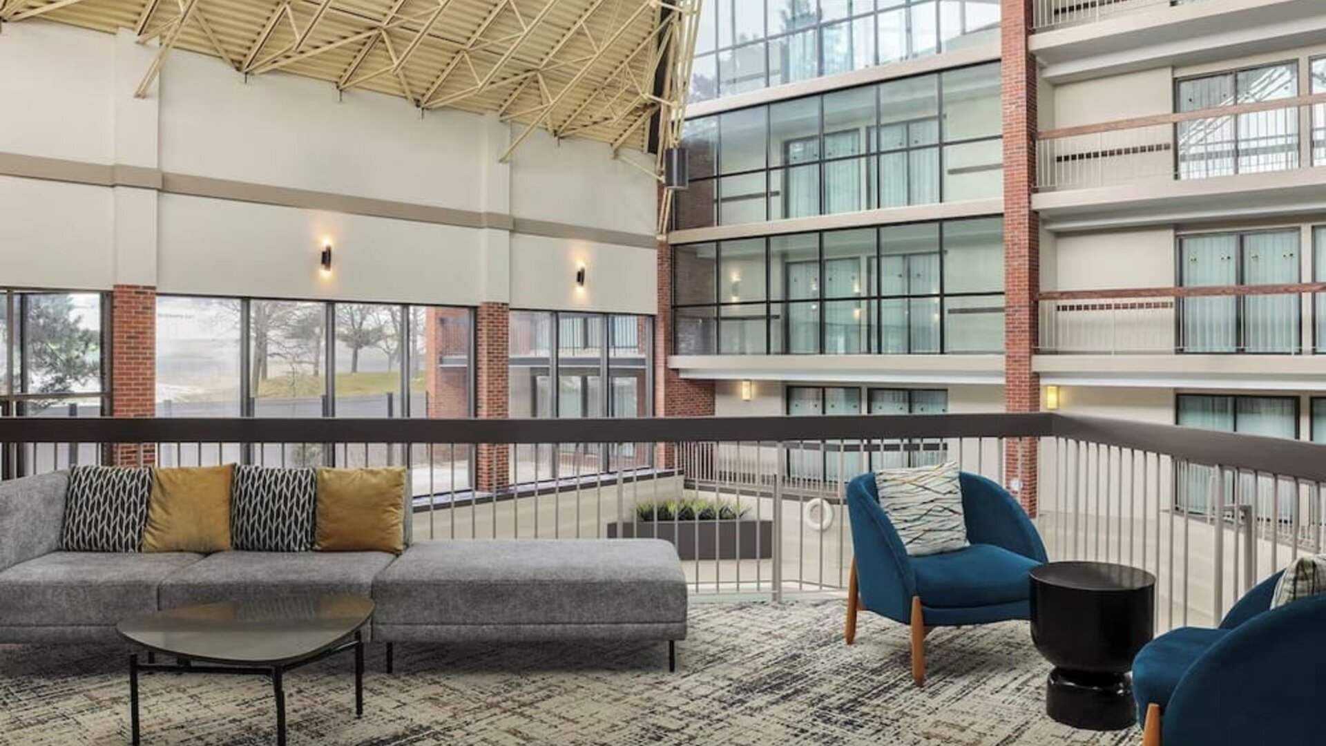 Bright open-air atrium lounge with comfortable seating and natural light at Holiday Inn Oakville Centre.