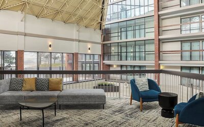 Bright open-air atrium lounge with comfortable seating and natural light at Holiday Inn Oakville Centre.