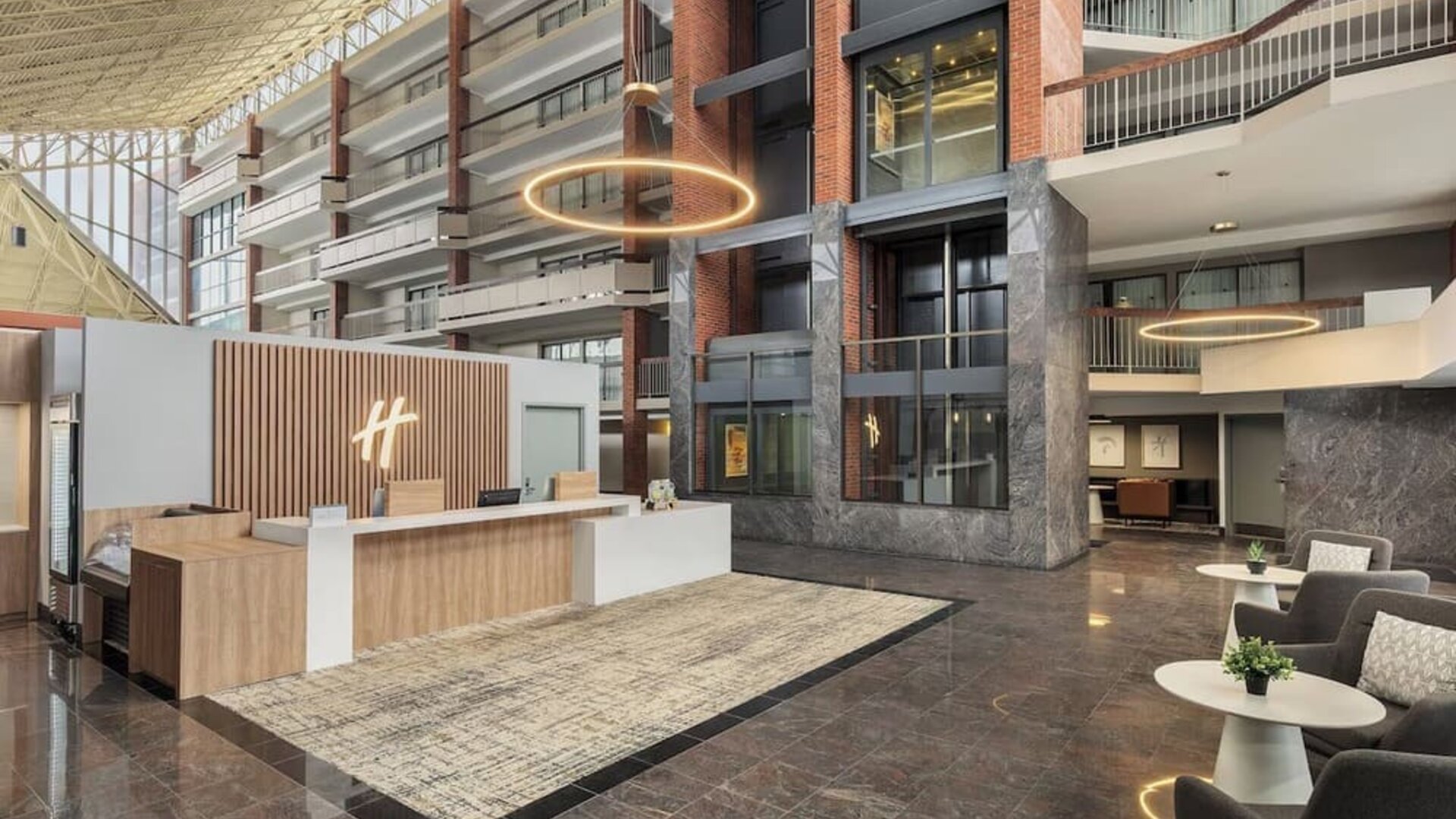 Modern reception area with welcoming front desk and spacious atrium lobby at Holiday Inn Oakville Centre.