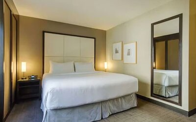 Contemporary guest room featuring a plush king bed, premium linens, and modern furnishings at ARC The Hotel Ottawa.