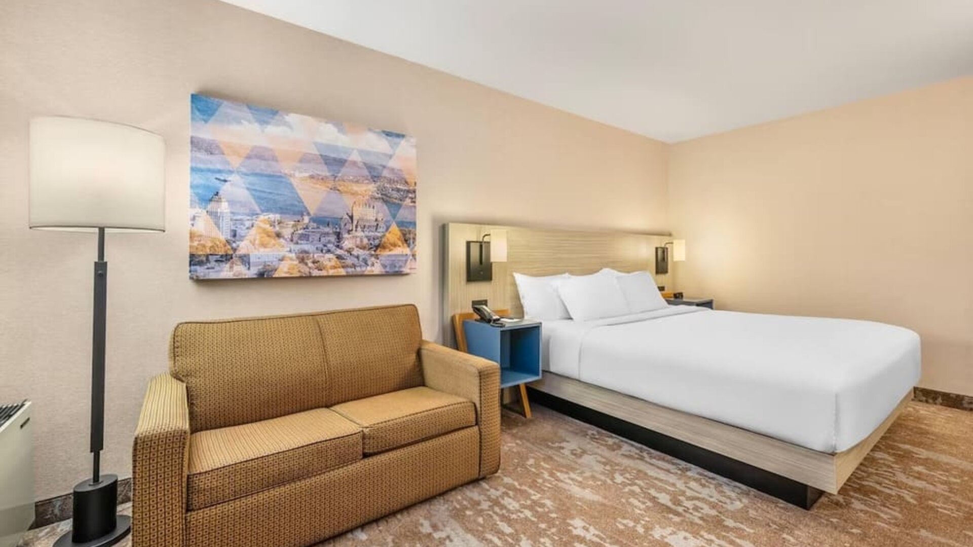 Comfortable day-use guest room with a king bed, sofa, and modern amenities, ideal for work or daytime relaxation at Comfort Inn Airport East Ancienne-Lorette.