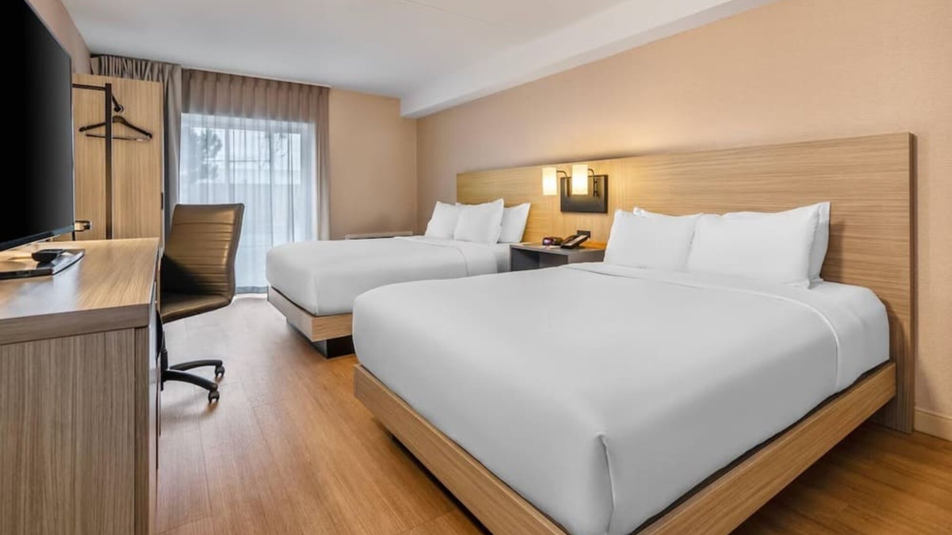 Bright guest room with two queen beds, a dedicated workspace, and modern amenities for families or groups at Comfort Inn Airport East Ancienne-Lorette.