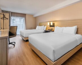 Bright guest room with two queen beds, a dedicated workspace, and modern amenities for families or groups at Comfort Inn Airport East Ancienne-Lorette.