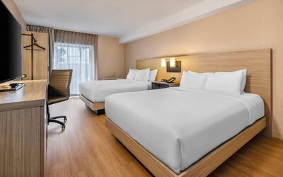 Bright guest room with two queen beds, a dedicated workspace, and modern amenities for families or groups at Comfort Inn Airport East Ancienne-Lorette.