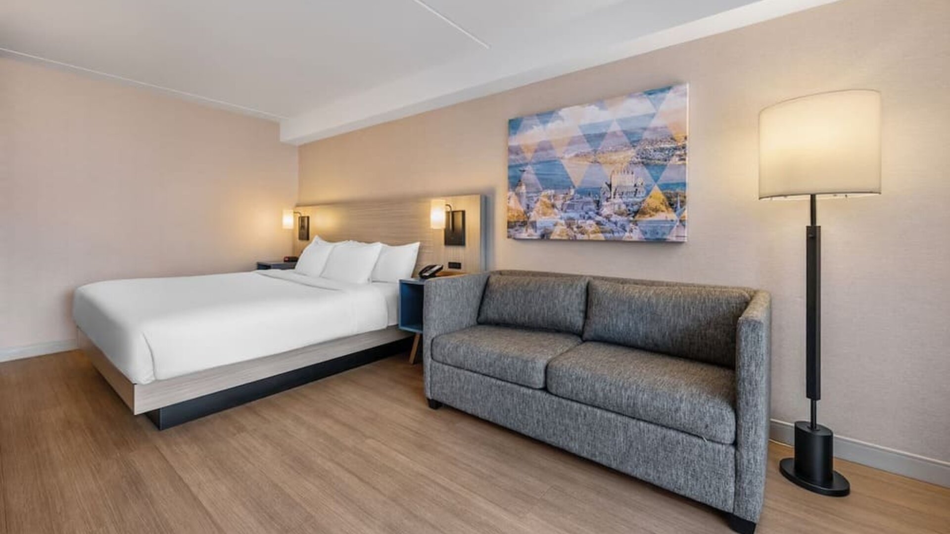 Spacious guest room featuring a king bed, comfortable sofa, and contemporary furnishings for a relaxing stay at Comfort Inn Airport East Ancienne-Lorette.