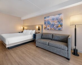 Spacious guest room featuring a king bed, comfortable sofa, and contemporary furnishings for a relaxing stay at Comfort Inn Airport East Ancienne-Lorette.