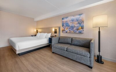 Spacious guest room featuring a king bed, comfortable sofa, and contemporary furnishings for a relaxing stay at Comfort Inn Airport East Ancienne-Lorette.
