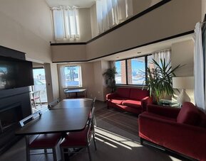 Bright lobby lounge with comfortable seating, dining tables, and a relaxing atmosphere at Comfort Inn Baie-Comeau.