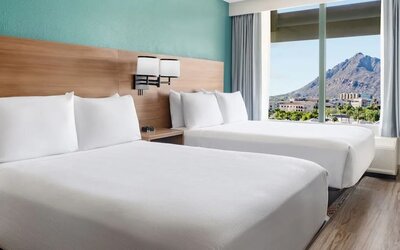 Double queen guest room featuring two plush beds, modern furnishings, and stunning mountain views at Hyatt Place Scottsdale/Old Town.