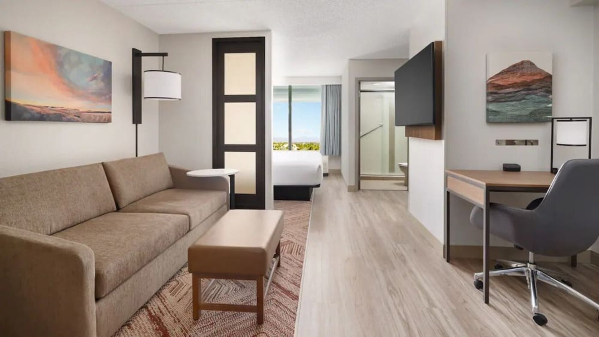 Spacious suite featuring a separate living area, sofa sleeper, dedicated workspace, and modern amenities at Hyatt Place Scottsdale/Old Town.