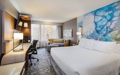 Spacious king guest room with a plush king bed, comfortable seating area, ergonomic workspace, and modern amenities at Courtyard Riverside UCR/Moreno Valley Area.