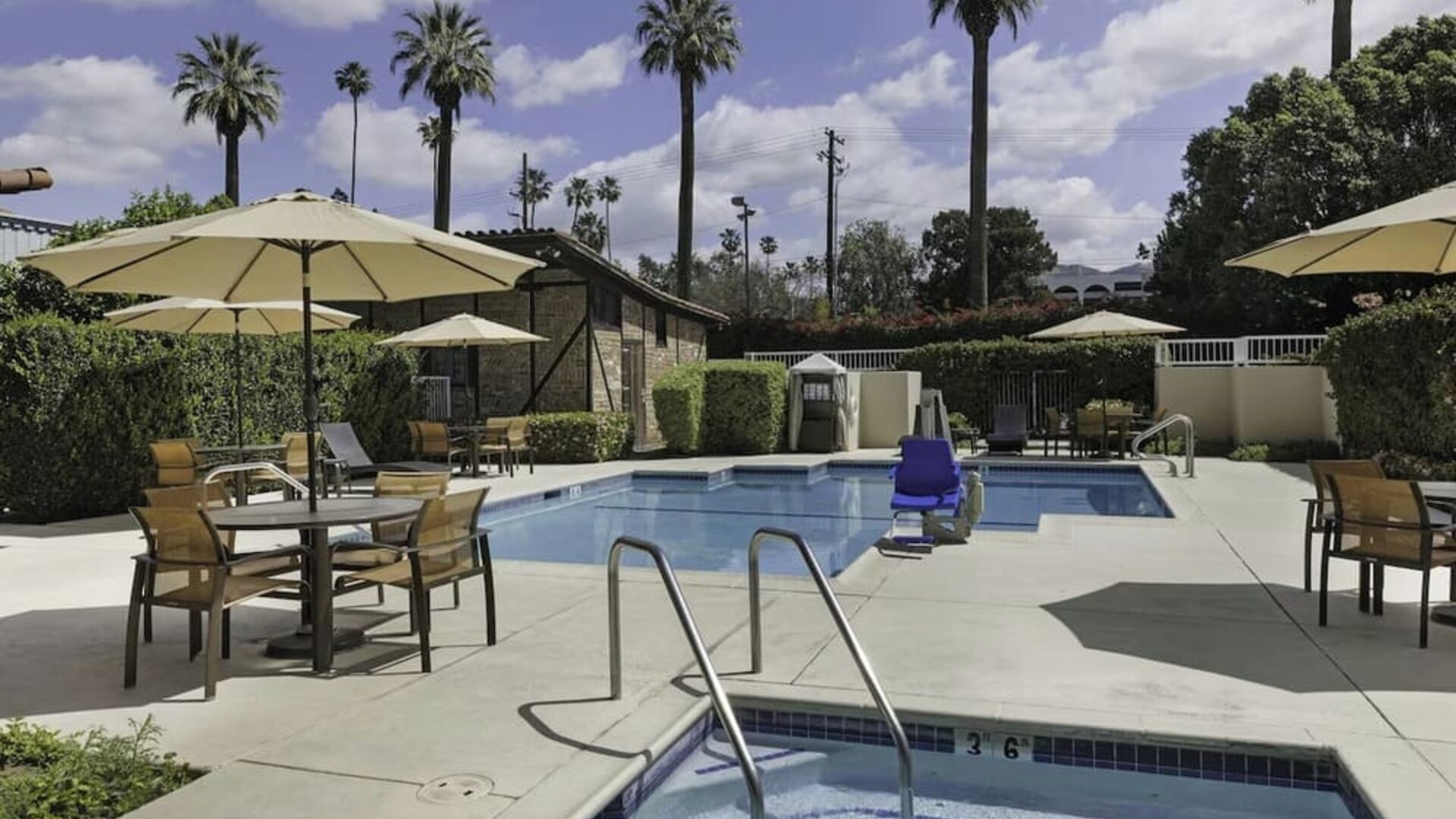 Outdoor swimming pool and whirlpool spa surrounded by lounge seating and shaded patio areas at Courtyard Riverside UCR/Moreno Valley Area.