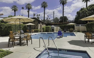 Outdoor swimming pool and whirlpool spa surrounded by lounge seating and shaded patio areas at Courtyard Riverside UCR/Moreno Valley Area.