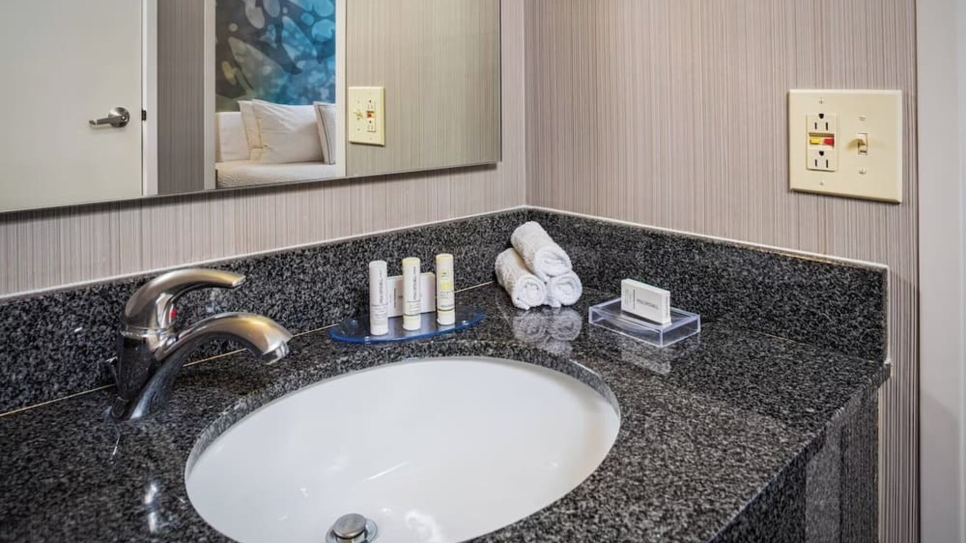 Modern bathroom vanity with granite countertop, premium toiletries, and fresh towels at Courtyard Riverside UCR/Moreno Valley Area.