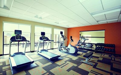 Well-equipped fitness center with treadmills, elliptical machines, free weights, and strength-training equipment at Courtyard Riverside UCR/Moreno Valley Area.