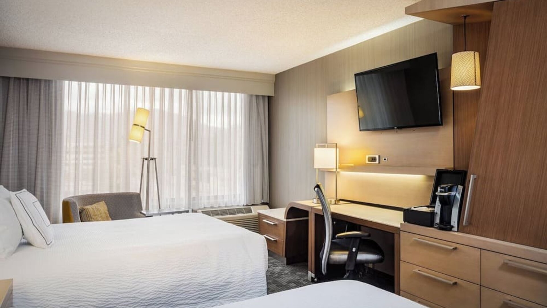 Guest room with two comfortable queen beds, spacious workstation, HDTV, and modern furnishings at Courtyard Riverside UCR/Moreno Valley Area.