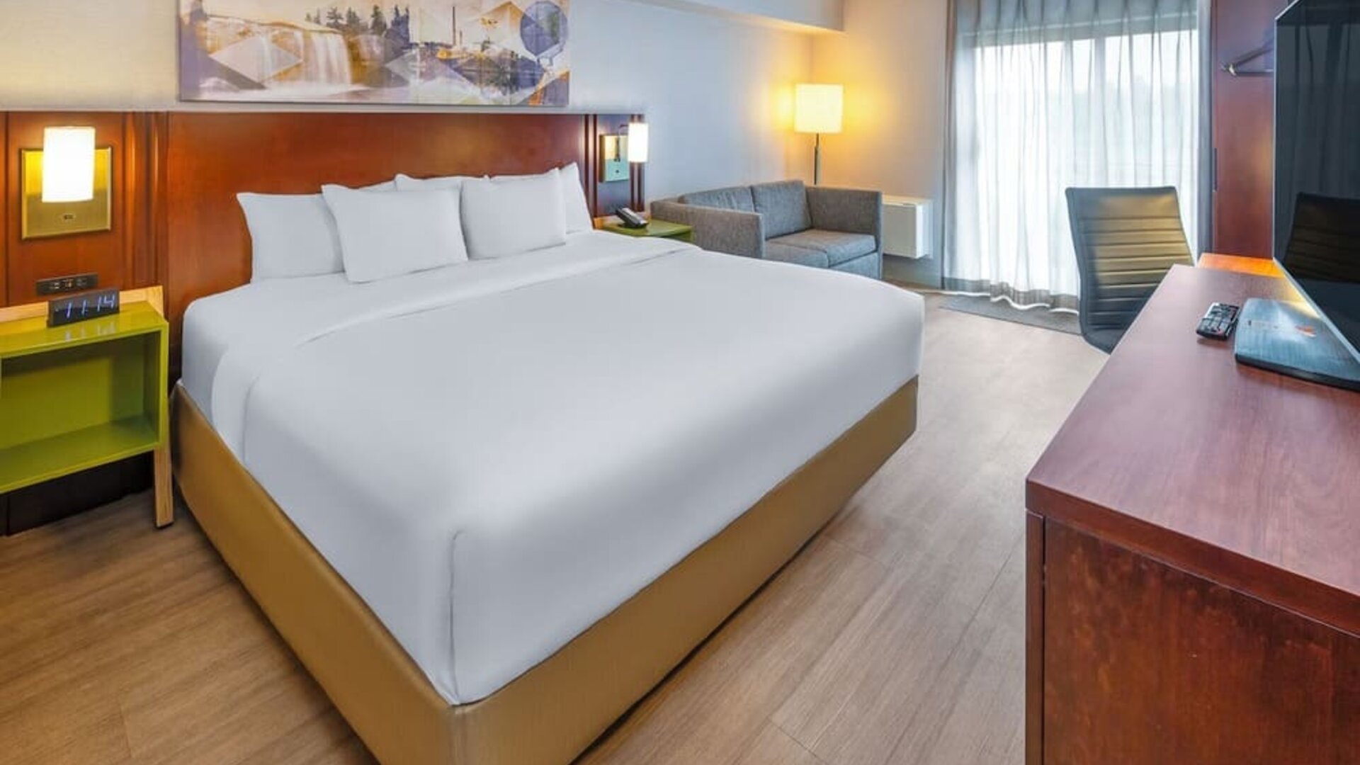 Spacious king guest room with plush bedding, seating area, and work desk at Comfort Inn Sudbury East.
