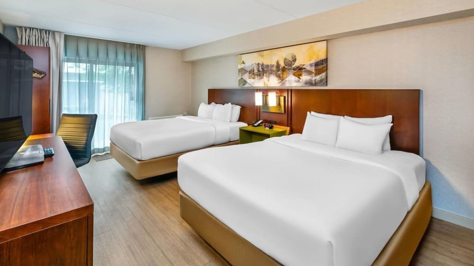 Guest room with two queen beds, hardwood flooring, workspace, and modern décor at Comfort Inn Sudbury East.