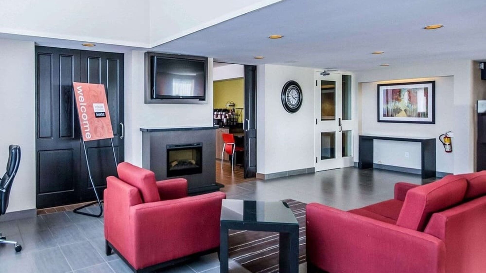 Lobby lounge featuring comfortable seating, fireplace, and access to the breakfast area at Comfort Inn Sudbury East.