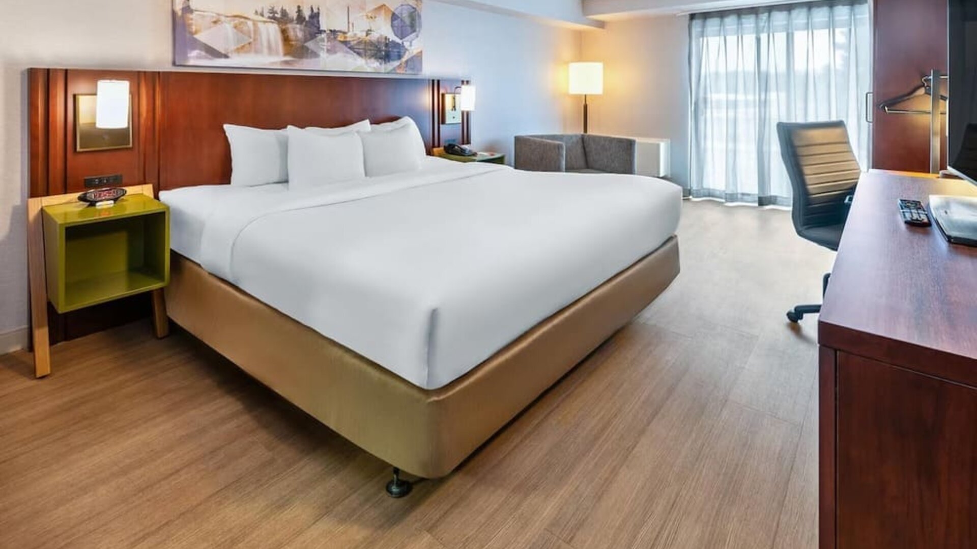 Spacious king guest room with a work desk, seating area, and contemporary furnishings at Comfort Inn Sudbury East.
