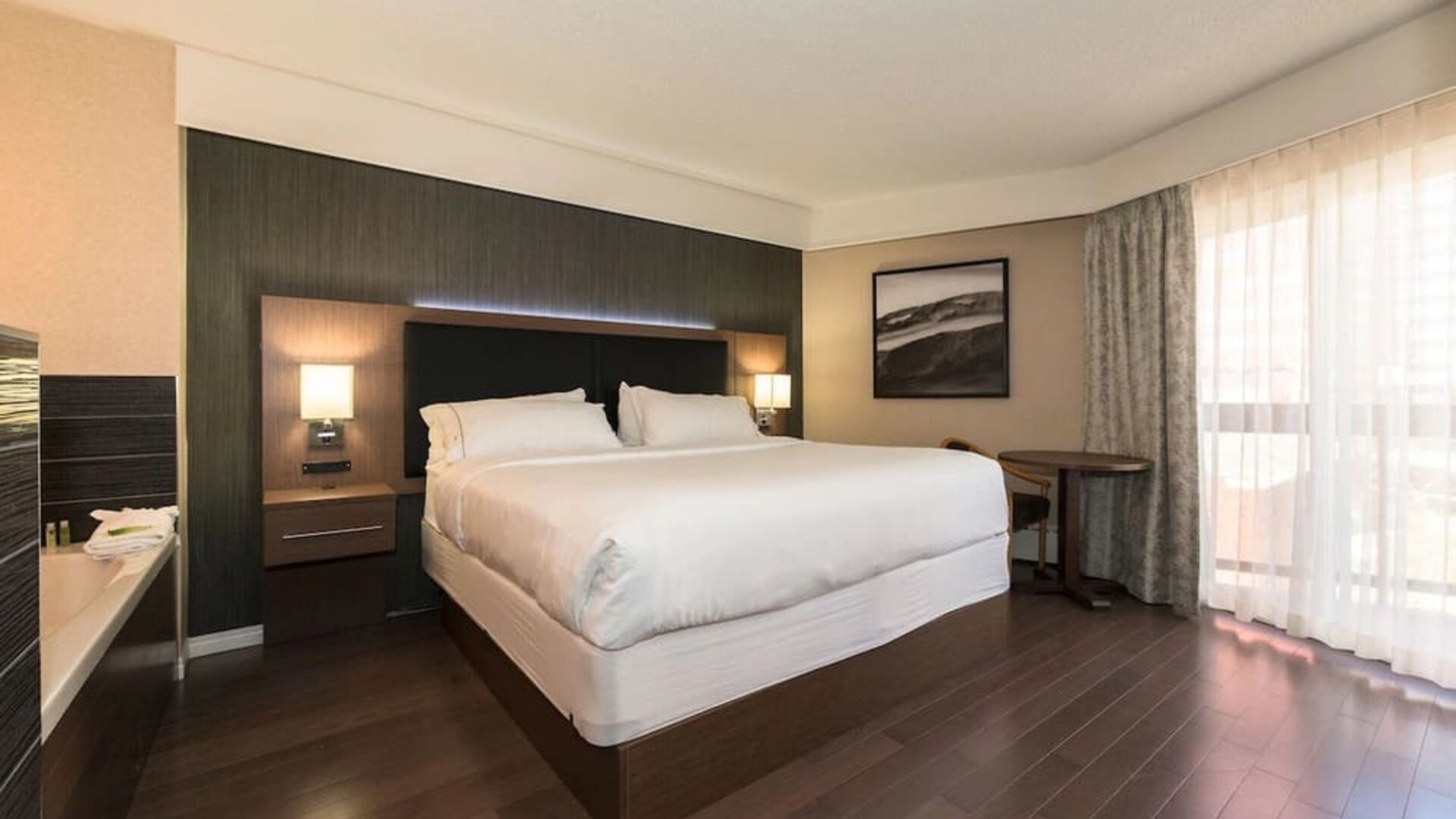 Spacious king guest room with hardwood flooring, modern décor, and natural light at Holiday Inn Express Edmonton Downtown, an IHG Hotel.
