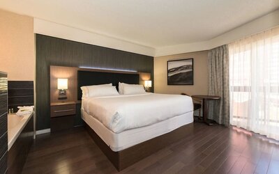 Spacious king guest room with hardwood flooring, modern décor, and natural light at Holiday Inn Express Edmonton Downtown, an IHG Hotel.