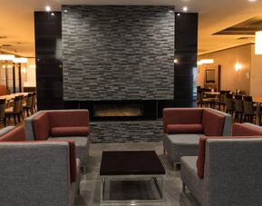 Lobby seating area with a fireplace and contemporary furnishings at Holiday Inn Express Edmonton Downtown, an IHG Hotel.