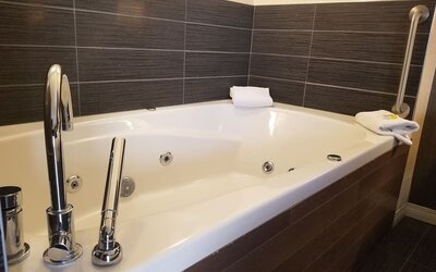 Guest bathroom with a jetted soaking tub at Holiday Inn Express Edmonton Downtown, an IHG Hotel.