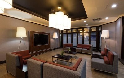 Modern hotel lobby with comfortable seating, large TV, and stylish lighting at Holiday Inn Express Edmonton Downtown, an IHG Hotel.