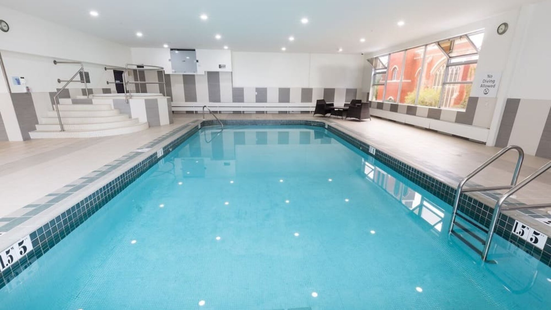 Indoor swimming pool with lounge seating at Holiday Inn Express Edmonton Downtown, an IHG Hotel.