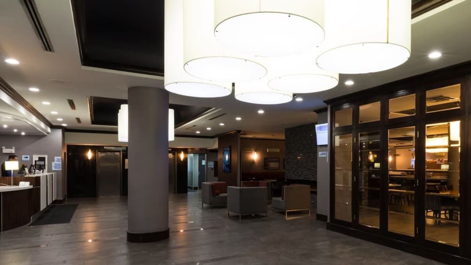 Bright hotel lobby with modern lighting, seating areas, and contemporary design at Holiday Inn Express Edmonton Downtown, an IHG Hotel.