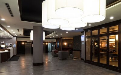 Bright hotel lobby with modern lighting, seating areas, and contemporary design at Holiday Inn Express Edmonton Downtown, an IHG Hotel.